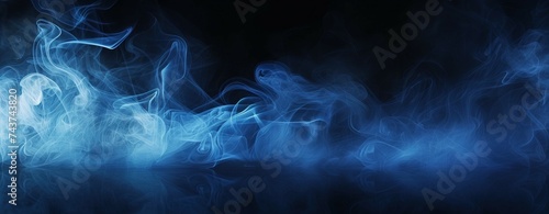 Blue smoke undulating softly in the darkness, creating an abstract and mysterious atmosphere photo