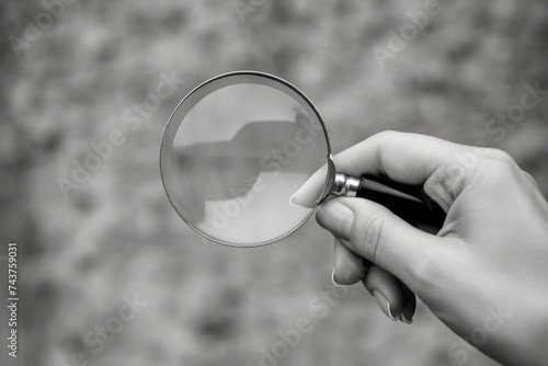 Close-up of hand holding magnifying glass