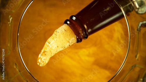 Freeze motion of pouring beer into pint. Unique angle of view from the bottom of the glass.