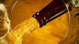 Freeze motion of pouring beer into pint. Unique angle of view from the bottom of the glass.