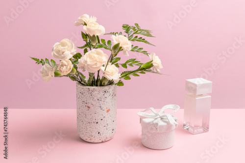 Fototapeta Naklejka Na Ścianę i Meble -  Bouquet of carnations in a vase with a gift box and a perfume.