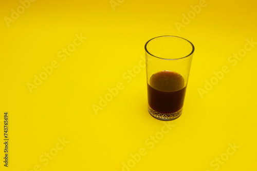 a glass of coffee isolated on yellow background