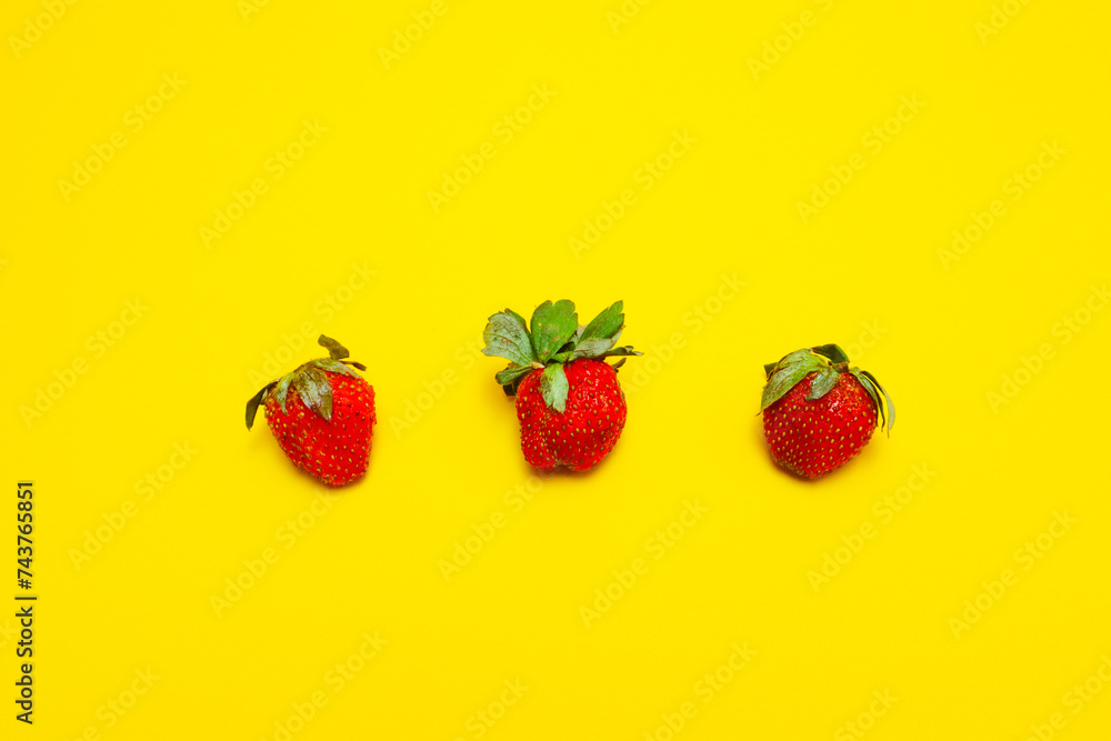 photo of strawberries isolated on yellow background photo of strawberries isolated on yellow background
