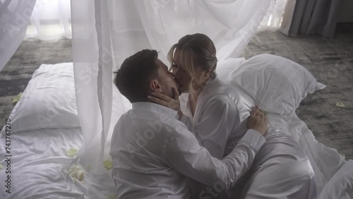A couple sharing a romantic moment under a canopy, kissing in the darkness