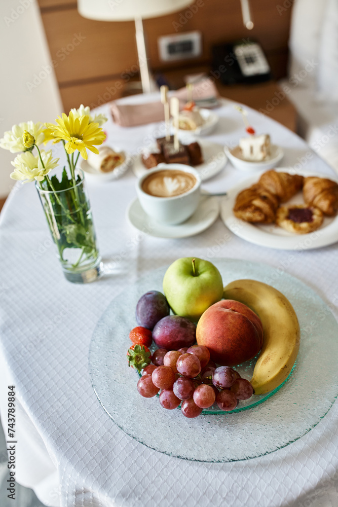 Hotel room service with fresh cappuccino and a variety of breakfast food, flowers and fruits Hotel room service with fresh cappuccino and a variety of breakfast food, flowers and fruits