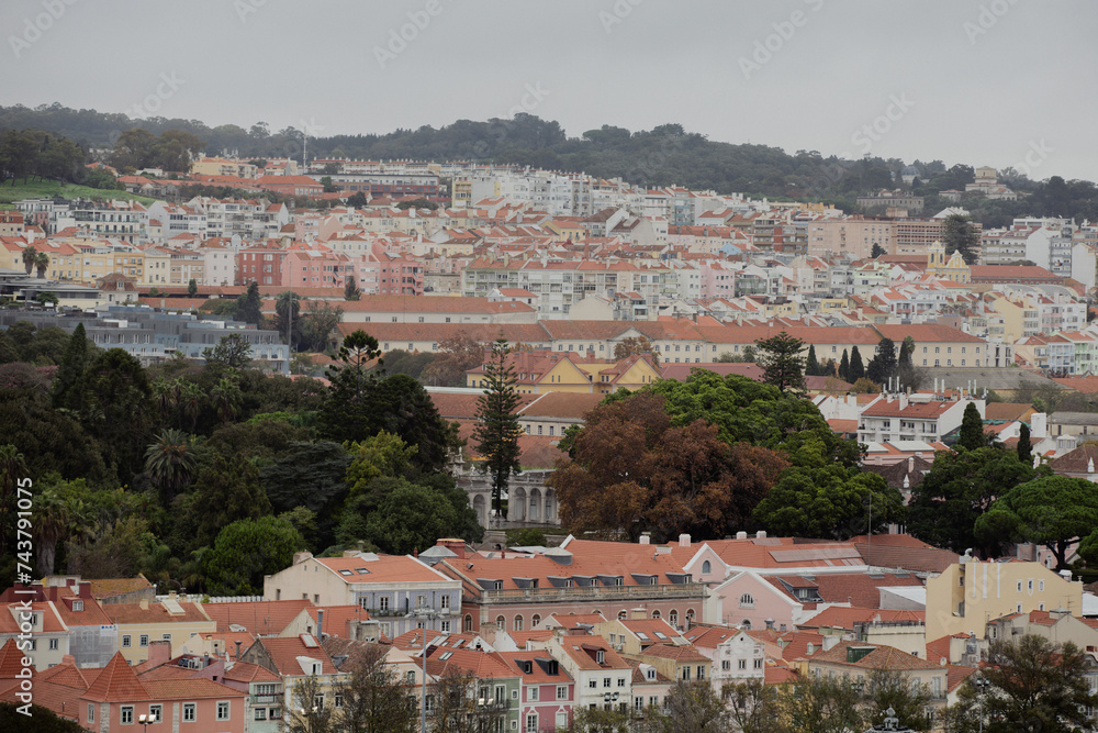 panorama view with red roofs and green trees and bushes of city lisbon in portugal