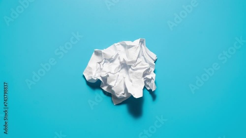 Stop motion animation of crumpled pape on a blue background. High quality 4k footage
