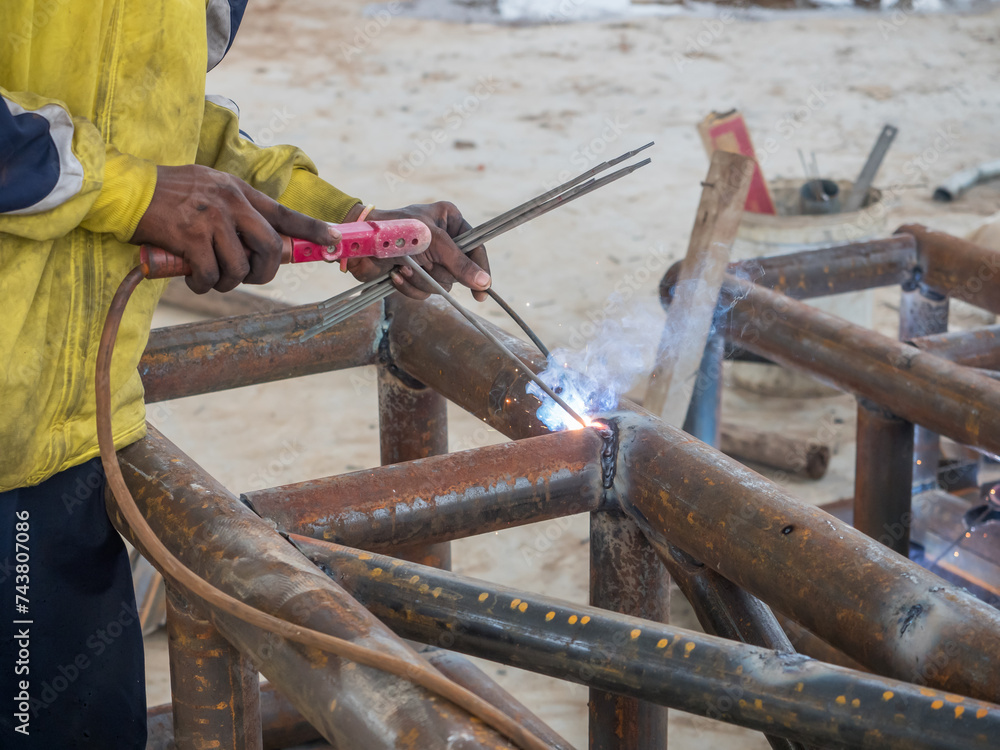 Welding of metal column trusses for building a factory.