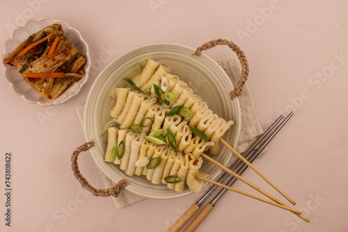 Eomuk Guk or Odeng Guk is Korean Fish Cake Skewer in Korean Soup, Served With Kimchi.  Korean Street Food Style. photo