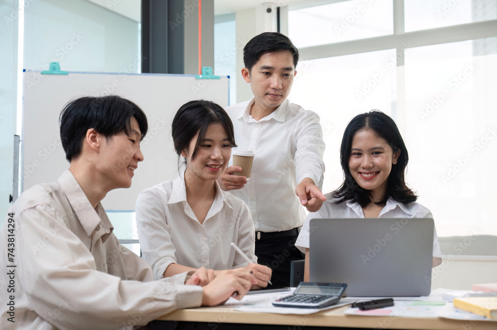 team of Asian businessmen meets to brainstorm ideas about office work management in an office conference room. team of Asian businessmen meets to brainstorm ideas about office work management in an office conference room.