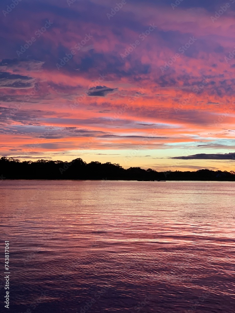 Beautiful sunset on Amazon river. Peru. Amazonia. Colorful fantastic cloudy sky in summer. Before the rain in evening. Nature landscape. Scenery