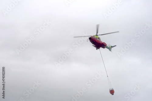 firefighting helicopter with carry bucket for water flying near Algeciras, Andalusia, Spain, Forest fire, drought, 