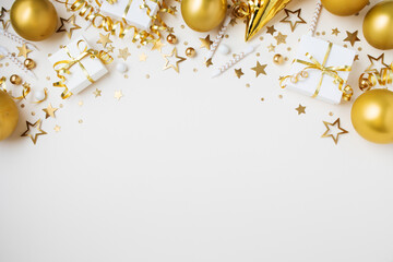 Golden birthday party background with festive decoration from gift box, balloons, carnival hat, candles, confetti, candy and streamers top view.