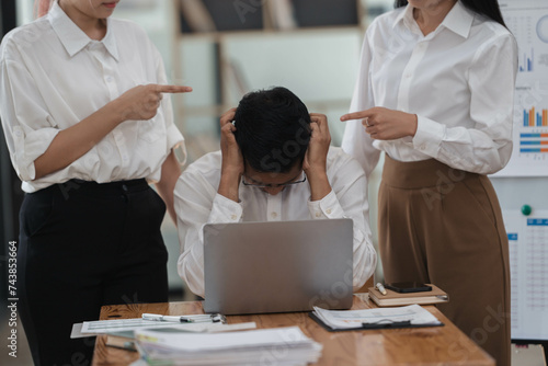 Frustrated Asian employee feels stressed suffers from hostile coworkers.