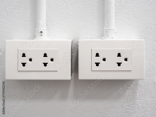 white electrical power socket box on white wall, renovation concept, home under construction	