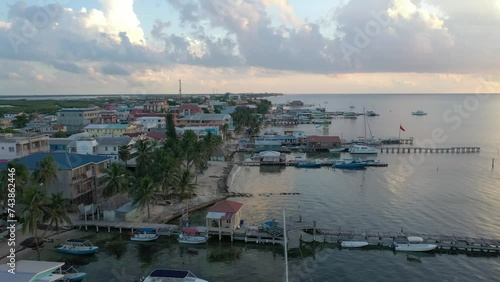 Aerial drone view of San Pedro, Ambegris Caye in Belize during sunrise. Flying over tropical Caribbean island. Boats and docks.