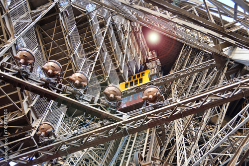 Elevator among metal beams inside the Eiffel Tower
