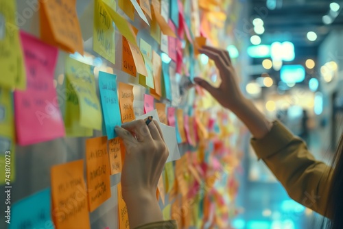 Close-up of hands placing sticky notes on an office wall during a collaborative and creative team meeting. 8k