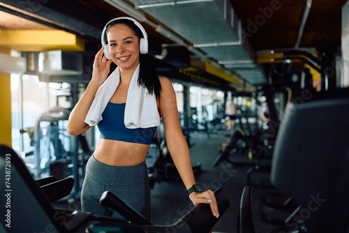 Portrait of young happy sportswoman exercising in health club and looking at camera.