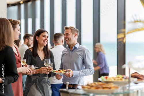Group of professionals enjoying a light-hearted moment during a networking event, with drinks and snacks, in a modern office setting.

