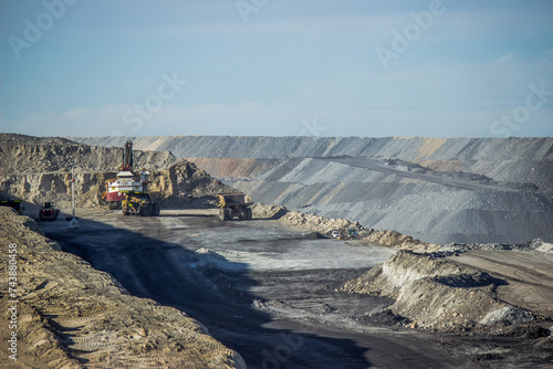 Dump trucks loading up with slag in open cut coal mine photo
