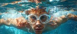 A determined swimmer navigates the crystal blue depths of the pool, donning goggles to shield his human face as he glides through the water with effortless grace and precision