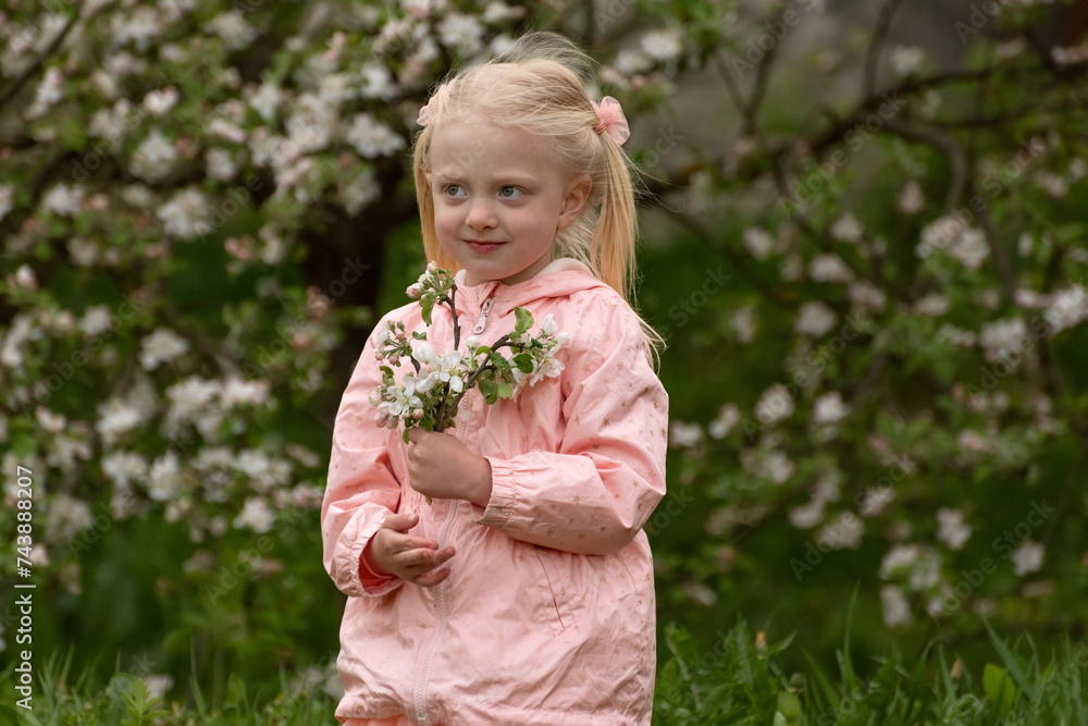 Little pretty girl with two tails enjoy spring apple blooming. Springtime. Preschool girl in flowering garden. Little pretty girl with two tails enjoy spring apple blooming. Springtime. Preschool girl in flowering garden.