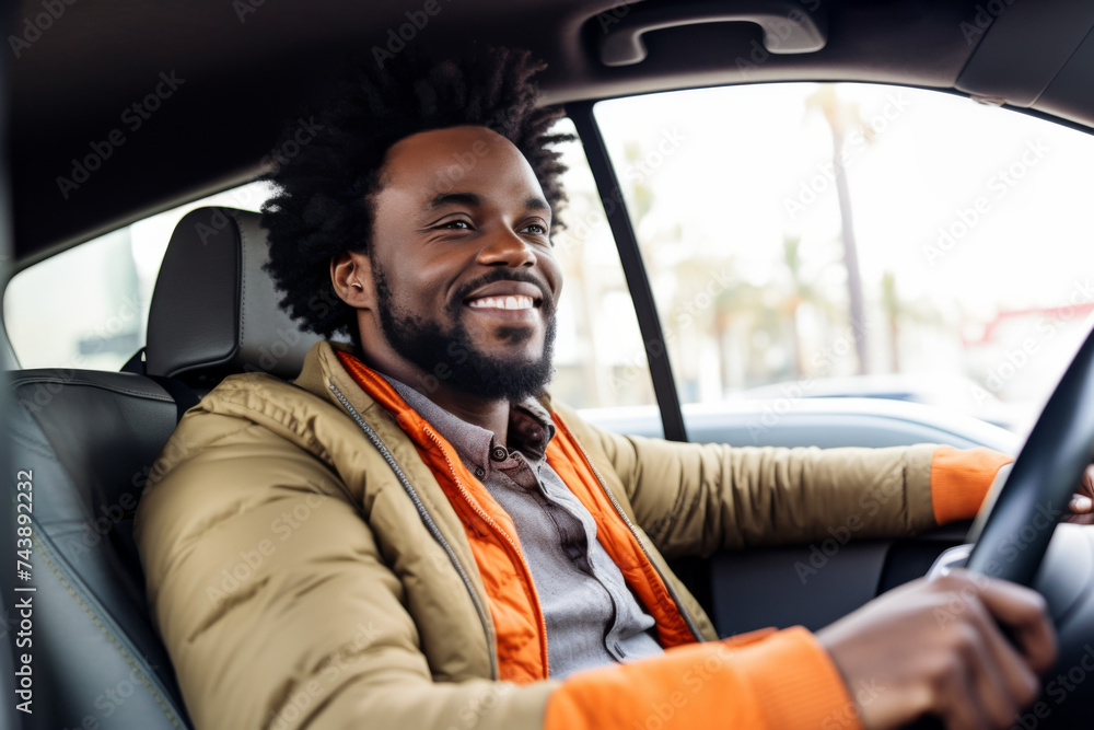 cheerful African American man sits behind the wheel of his new car cheerful African American man sits behind the wheel of his new car