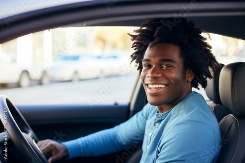African American man sits behind the wheel of his new car © mimagephotos