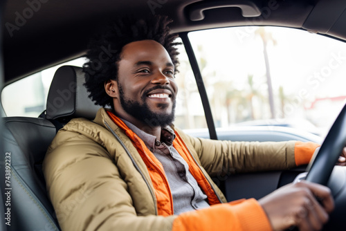 cheerful African American man sits behind the wheel of his new car
