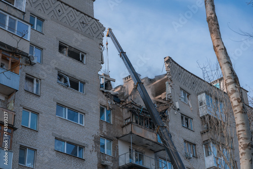 An attack drone (shahed) hit the roof of a house. Rocket attack on a residential building in the city of Dnepr. Consequences after a strong explosion. War in Ukraine and Russia. People under the rubbl photo