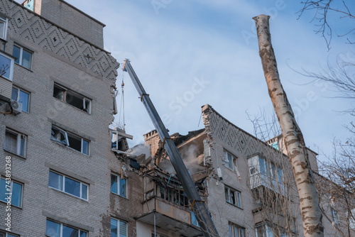 An attack drone (shahed) hit the roof of a house. Rocket attack on a residential building in the city of Dnepr. Consequences after a strong explosion. War in Ukraine and Russia. People under the rubbl photo