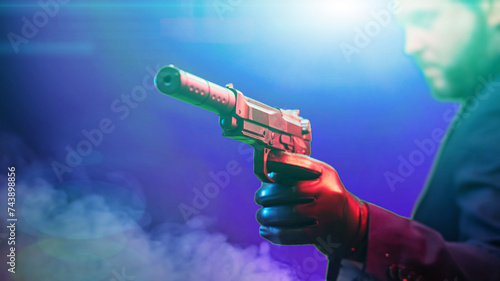 close-up of a pistol with a silencer in the killer's hand photo