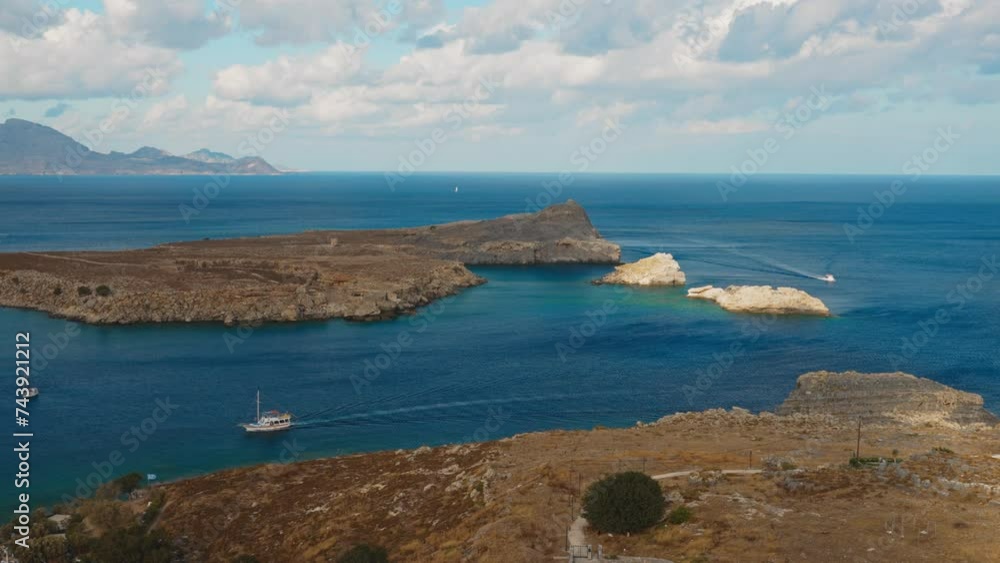 Picturesque view of Lindos Bay surrounded by mountains. Picturesque view of Lindos Bay surrounded by mountains.