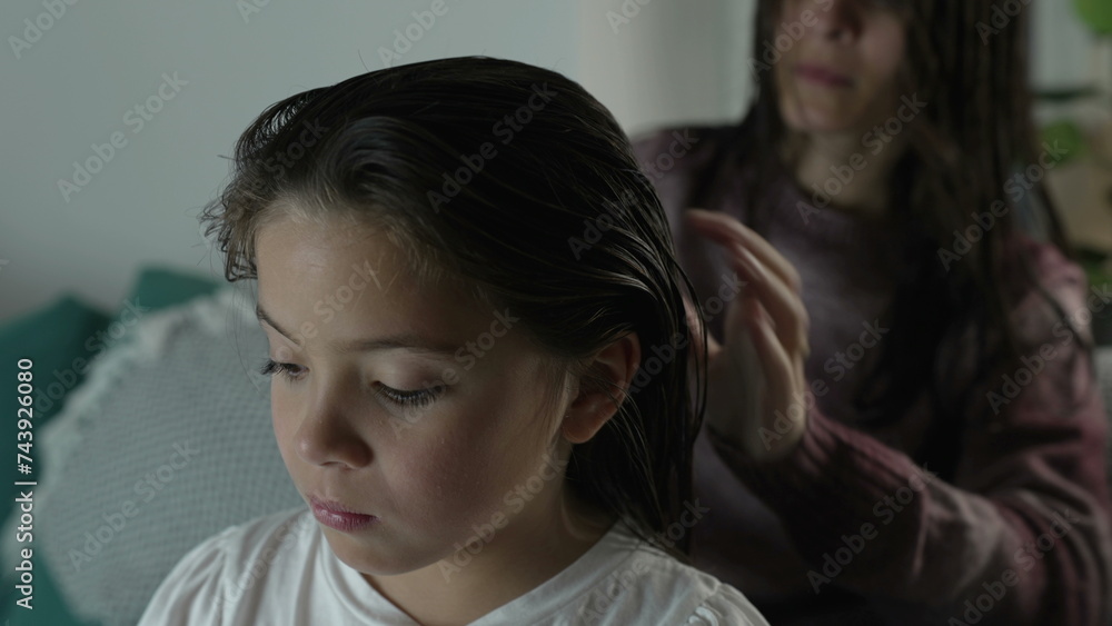 Family Bedtime Routine, Mother Gently Combing Daughter's Hair at Night Family Bedtime Routine, Mother Gently Combing Daughter's Hair at Night