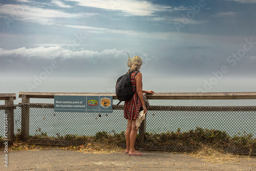 Papier peint A woman, on a round-the-world adventure tour, looks out over the Pacific Ocean from Cape Byron, the easternmost point of the mainland of Australia