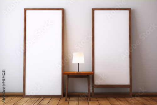 Two minimal wooden frames and a table with a lamp in front of a white wall