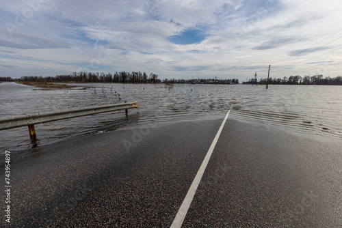 flooded road, early spring flood, river overflowing its banks, environmental pollution, ecology © Sergei