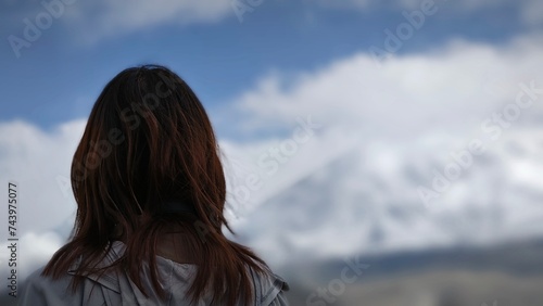 The woman's back and the snowy mountains in the distance