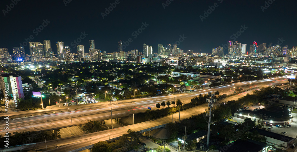 Aerial view of american highway junction at night with fast driving vehicles in Miami, Florida. View from above of USA transportation infrastructure