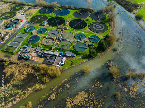 Aerial shot of sewage treatment plant next to flooded river Avon, UK
