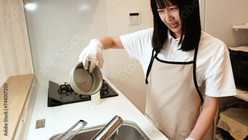 キッチンの排水口が臭くて鼻をつまむ女性 photo