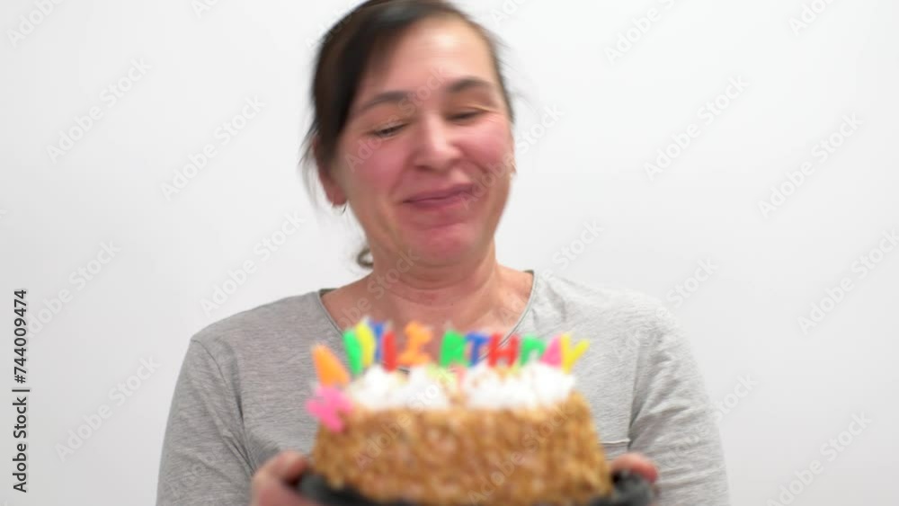 Happy elderly woman celebrating her birthday holding a cake with a candle. Happy elderly woman celebrating her birthday holding a cake with a candle.