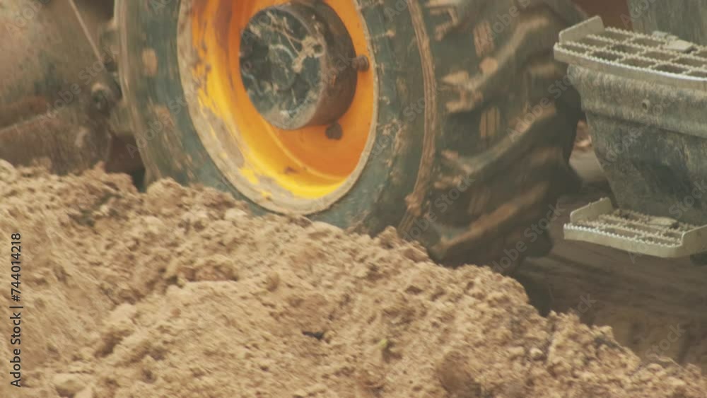 The wheel and tire of the tractor leaves a mark on the fresh sand. Off-road protector, close-up The wheel and tire of the tractor leaves a mark on the fresh sand. Off-road protector, close-up