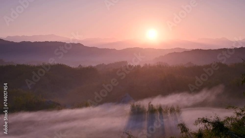 Morning sun and slow moving clouds in the valley. Silhouettes of mountains. The Erliao tribe in Zuozhen enjoys the sunrise landscape, Tainan City, Taiwan. photo