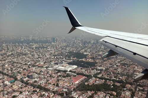 View on Mexico city through airplane window of commercial jet plane landing in local airport. Air travelling concept