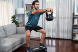 Athletic body and active sporty man doing squat with kettlebell weight for effective targeting muscle gain at gaiety home as concept of healthy fit body home workout lifestyle.