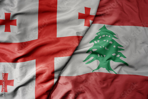 big waving national colorful flag of lebanon and national flag of georgia . photo