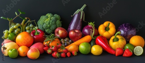 A group of different artificial fruits and vegetables are displayed on a black background.