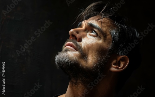 A man with a beard standing outdoors and gazing up at the sky